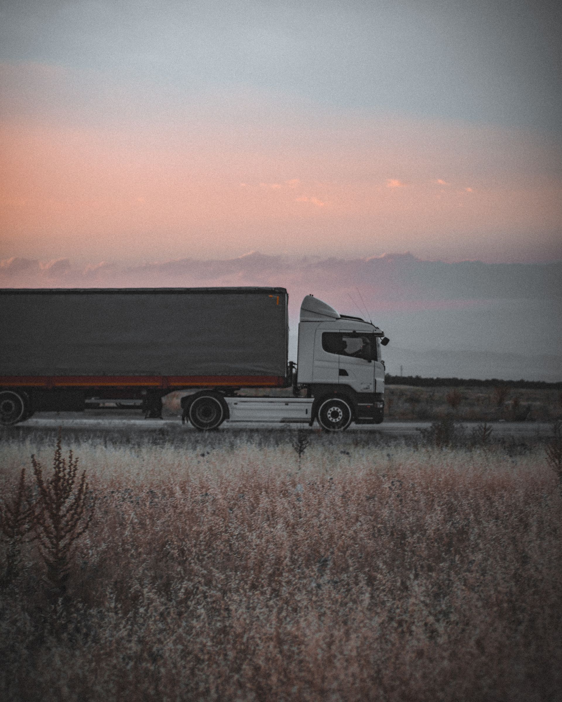 Cargo truck traveling on a highway at sunset