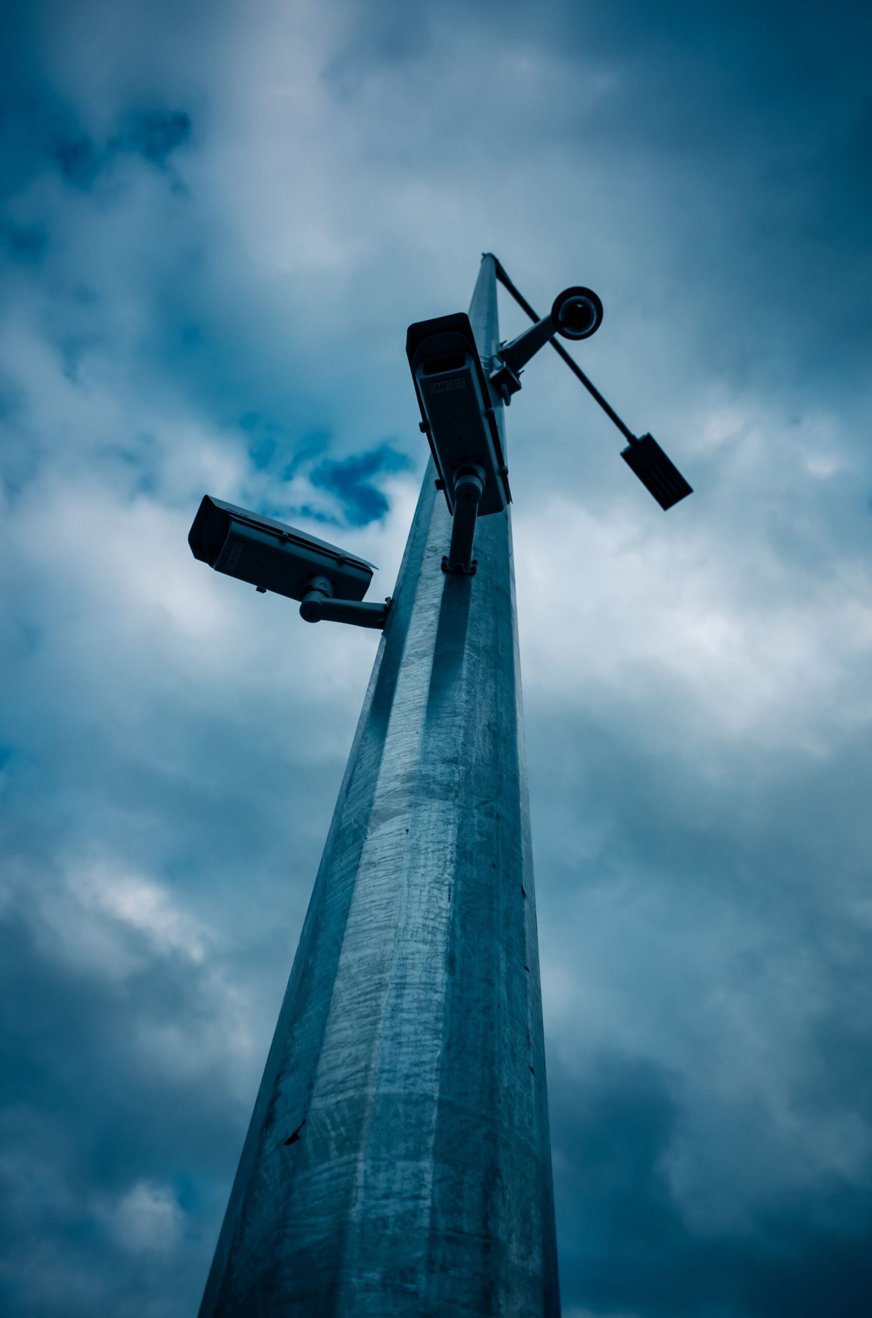CCTV cameras mounted on a tall pole against the sky