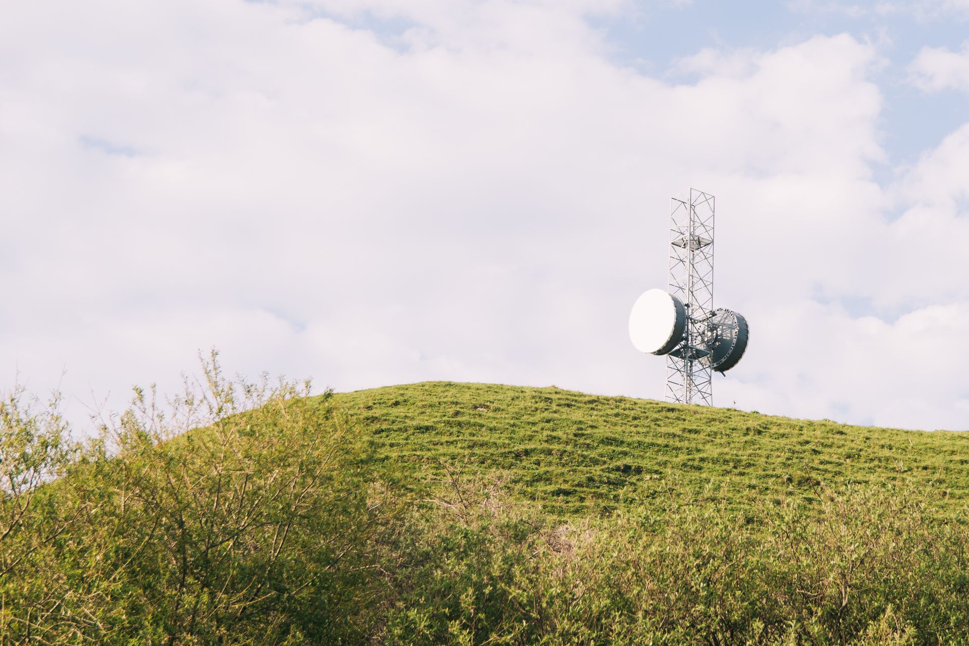 Communication tower on a grassy hill