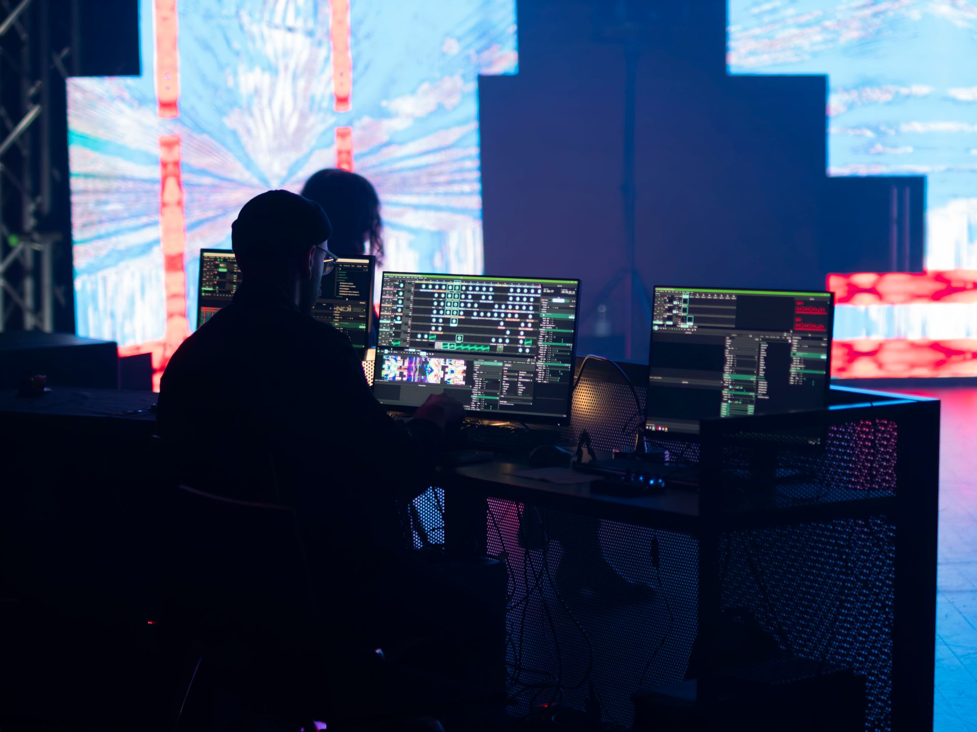 Technician operating multimedia visual equipment with screens