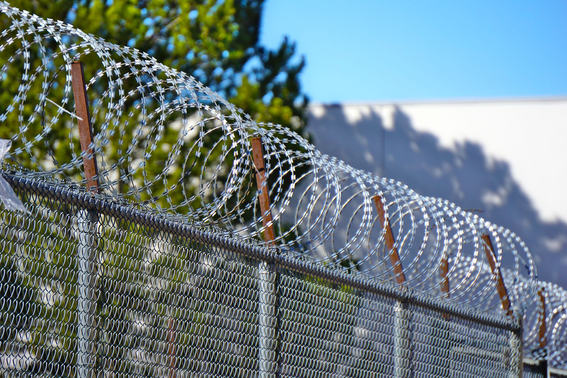 Security fence with barbed wire in bright daylight